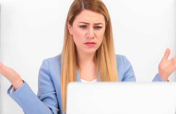 Mujer atractiva trabajando en un ordenador portátil en el malentendido de un gesto indefenso
. - Foto, Imagen