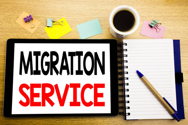 Word, writing Migration Service. Business concept for Online Network Idea Written on tablet laptop, wooden background with sticky note, coffee and pen - Photo, Image
