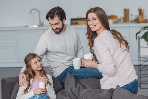 happy parents and daughter with drinks in morning - Photo, Image