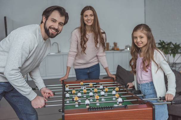 padre e hija jugando fútbol en casa y mirando a la cámara
 - Foto, Imagen