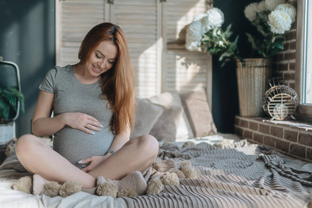 Femme enceinte touchant et regardant vers son ventre
 - Photo, image