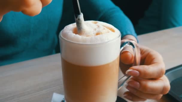 Γυναικεία χέρια είναι ανάδευση ο αφρός αέρα από το latte με άχυρο - Πλάνα, βίντεο