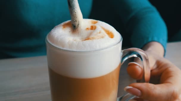 Női kezek megzörren a latte, szalmával a levegő habzik - Felvétel, videó