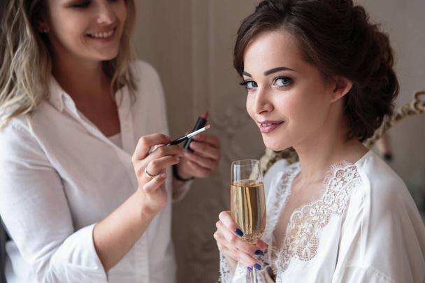 makeup artist preparing beautiful bride before the wedding in a morning - Φωτογραφία, εικόνα