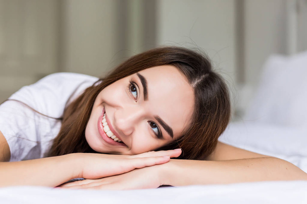 Charming woman smile face close up and she lying on the bed in the morning - Foto, Imagen