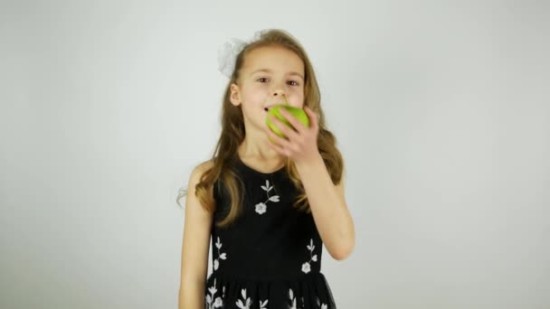 Lächelndes Mädchen isst einen grünen saftigen Apfel und sagt Yum. Äpfel knirschen beim Beißen. Originalton - Filmmaterial, Video