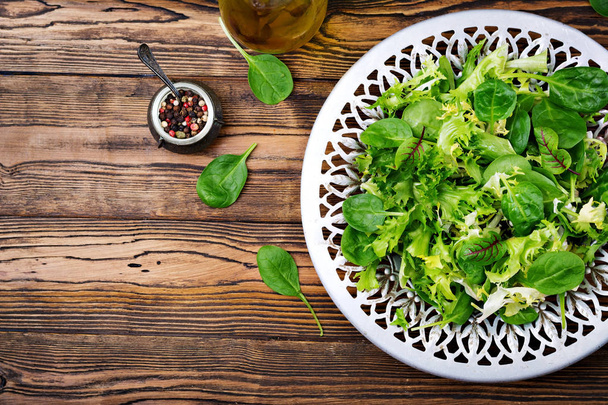 Vista superior de sabrosa ensalada vegetariana vegetariana orgánica casera en plato sobre mesa de madera
 - Foto, imagen
