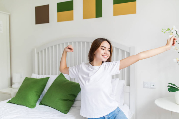 attractive woman stretching in the morning and is smiling with raised hands - 写真・画像