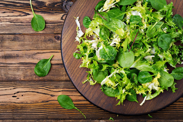 Fresh leaves of mix salad on a wooden background. Flat lay. Top view - Foto, immagini