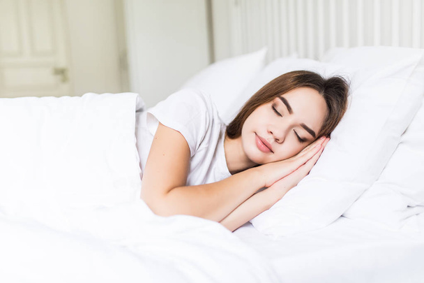 Junge schöne Frau schläft in ihrem Bett und entspannt sich am Morgen - Foto, Bild