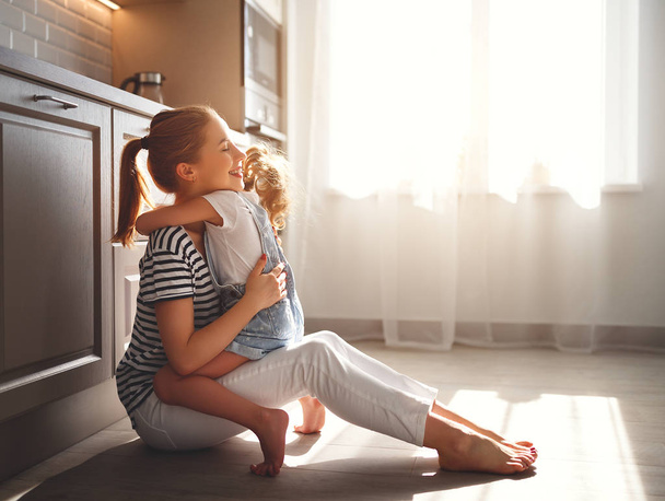сім'я мати і дитина дочка обіймається на кухні на плаву
 - Фото, зображення