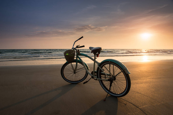 Il sole tramonta con la bicicletta sulla spiaggia
 - Foto, immagini