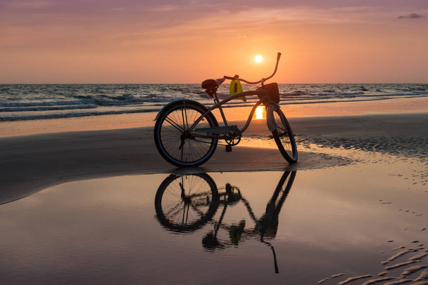 Il sole tramonta con la bicicletta sulla spiaggia
 - Foto, immagini