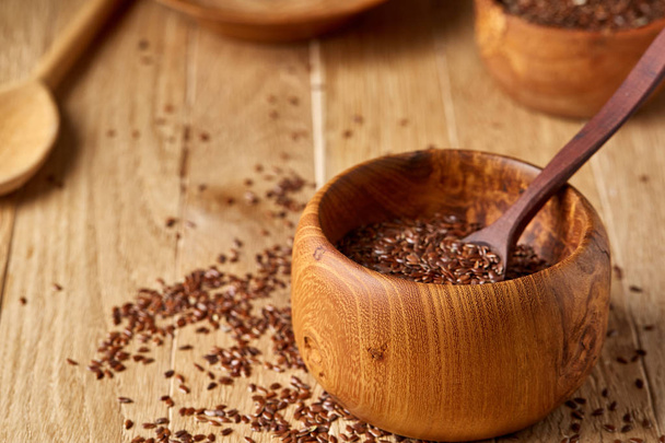 Wooden spoon with flax seeds on rustic background, top view, close-up, shallow depth of field, selective focus - Φωτογραφία, εικόνα