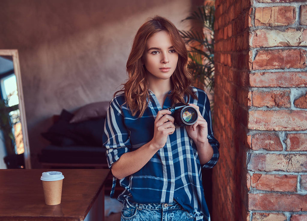 Young charming girl photographer stands in a room  - Foto, Imagem