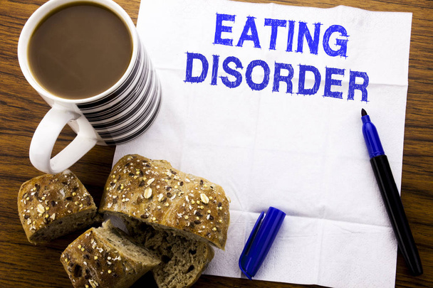 Kézzel írott szöveg mutatja, étkezési rendellenesség. Üzleti koncepció orvosi probléma szövet papír toll kenyér egészséges kávé az étteremben fából készült háttér - Fotó, kép