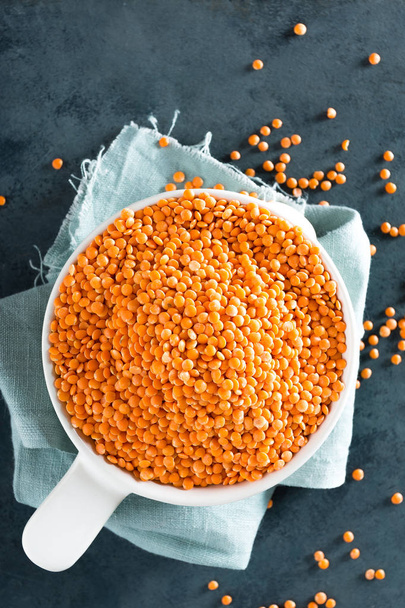 Raw lentil in bowl on table. Fresh lentils. Vegetarian food. Top view  - Valokuva, kuva