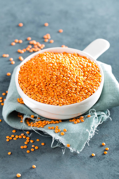 Raw lentil in bowl on table. Fresh lentils. Vegetarian food - 写真・画像