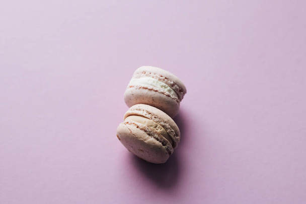 composition of two delicious colorful macaroons on magenta table, sweet dessert  - Fotoğraf, Görsel