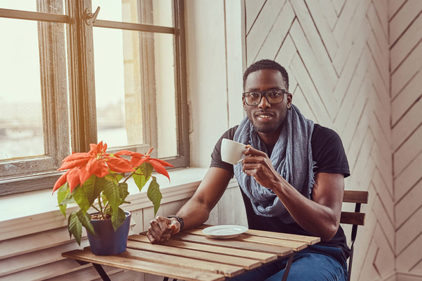 若いアフリカ系アメリカ人学生は、朝コーヒーを飲む - 写真・画像