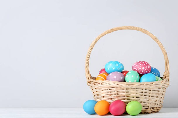 Colorful easter eggs in basket on grey background - Photo, Image