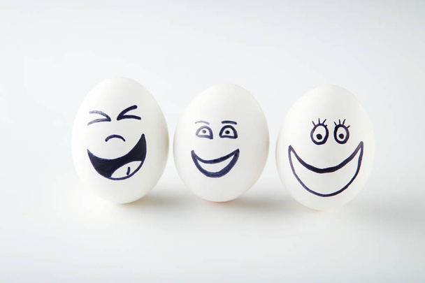 Eggs with funny faces on white background - Zdjęcie, obraz