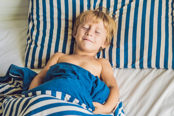 Cute boy woke up in his bed. Children sleep concept. - Фото, изображение
