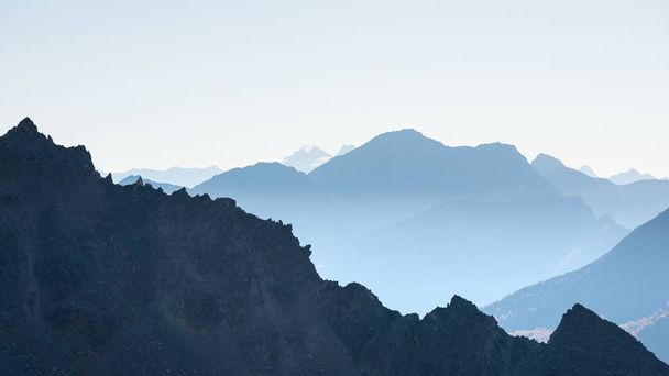 Silhouette de montagne lointaine avec ciel clair et lumière douce. Image tonique, filtre vintage, split toning
. - Photo, image