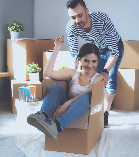 Happy young couple unpacking or packing boxes and moving into a new home - Fotó, kép