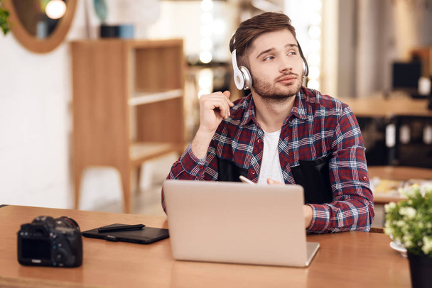 Freelancer man listening to music at laptop sitting at desk. - Фото, зображення