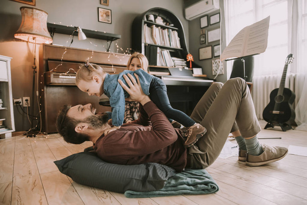 Happy young family playing on the floor  in the room - Foto, Imagen