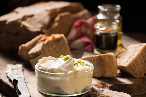Bread slices with cream cheese and herbs on board - Foto, Bild