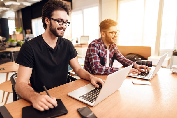Two freelancer men working at different laptops at desk. - Foto, imagen