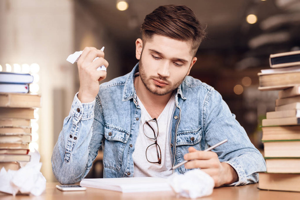 Freelancer man scratching paper notes sitting at desk. - Φωτογραφία, εικόνα