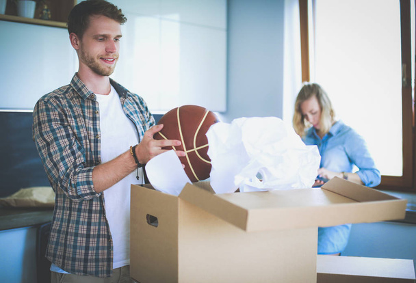 Couple unpacking cardboard boxes in their new home. Young couple. - Fotoğraf, Görsel