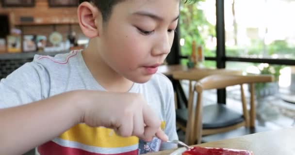 Happy asian child enjoy eating cake together - Materiał filmowy, wideo