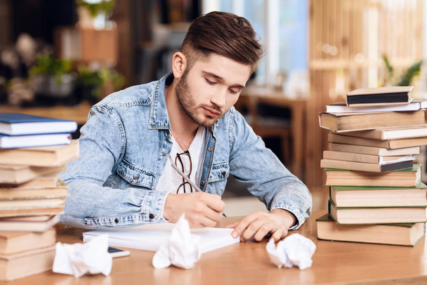 Freelancer man taking noteson paper sitting at desk. - Foto, Imagem
