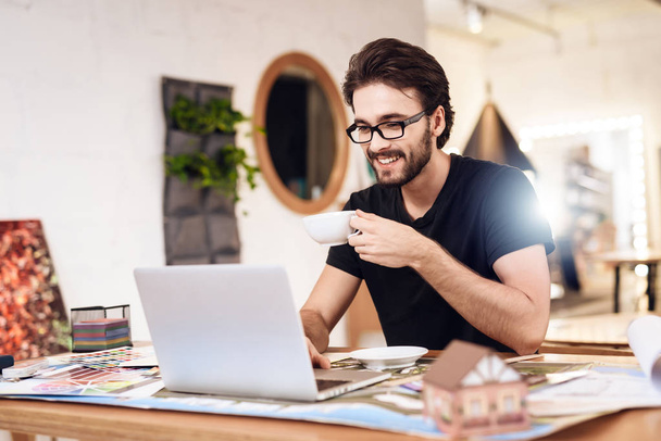 Freelancer bearded man drinking tea at laptop sitting at desk. - Zdjęcie, obraz