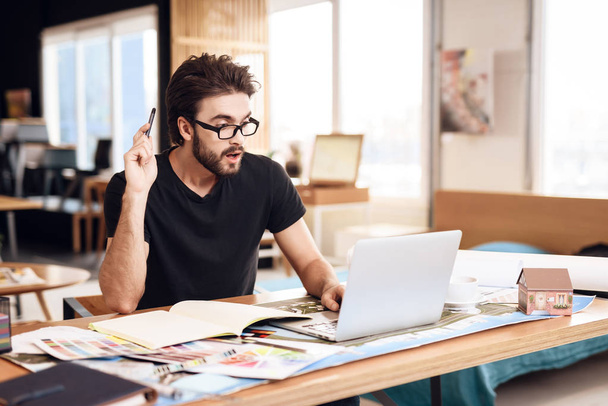 Freelancer bearded man taking notes at laptop sitting at desk. - Valokuva, kuva
