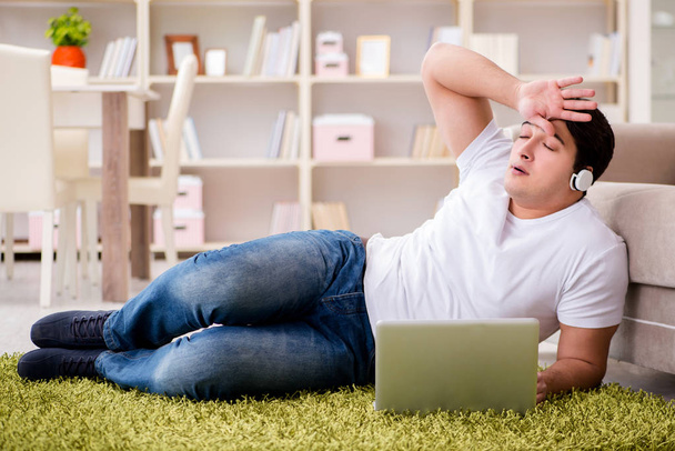 Man working on laptop at home on carpet floor - Foto, imagen