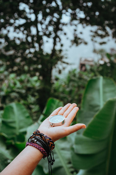 Hand with compass in the lush rainforest jungle - Φωτογραφία, εικόνα
