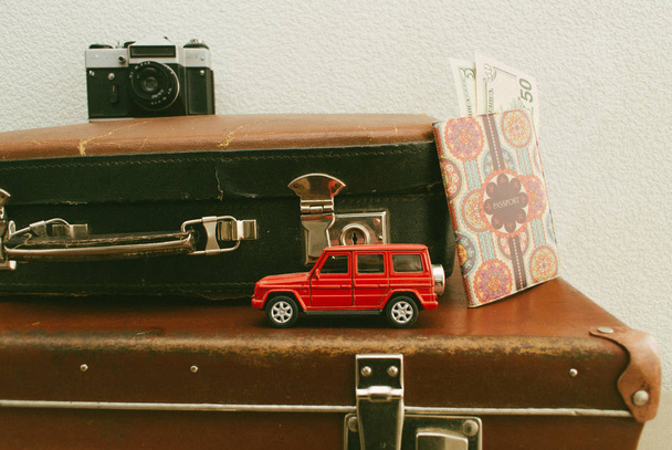 Part of vintage leather travel valises or old suitcase with passport, money, camera and toy car. Close up - Valokuva, kuva