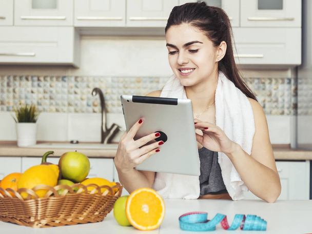 Woman Uses Tablet in Kitchen - Valokuva, kuva