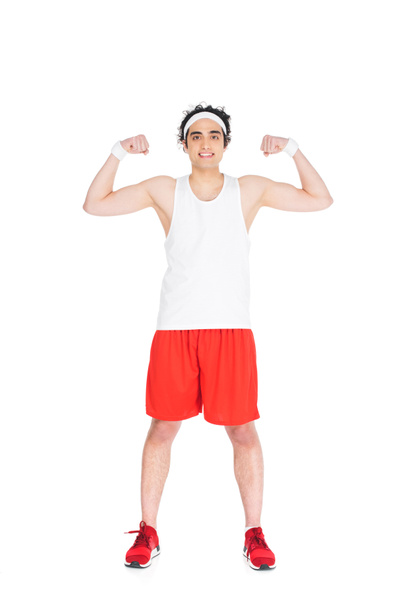 Young thin man in sportswear showing muscles isolated on white - Photo, Image