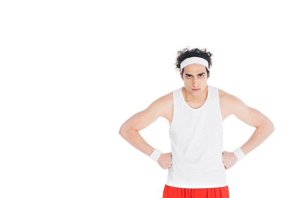 Тонкий серйозний спортсмен з руками на талії ізольований на білому
  - Фото, зображення