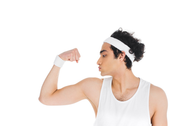 Side view of young thin sportsman showing muscles on hand isolated on white - Foto, afbeelding