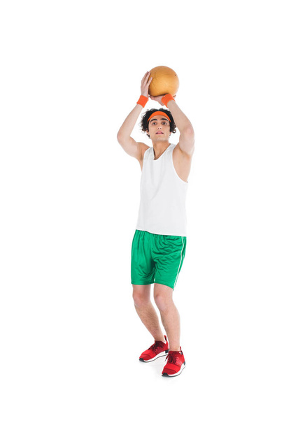 Skinny sportsman in headband preparing to throw ball isolated on white - Photo, Image