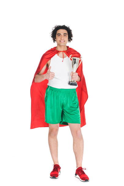 Deportista delgado con trofeo en las manos de pie en capa roja aislado en blanco
 - Foto, Imagen