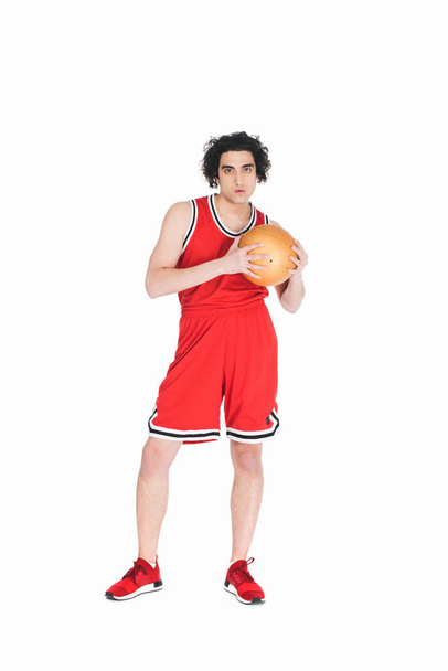Тощий баскетболист, стоящий с мячом в руках, изолированный на белом
 - Фото, изображение