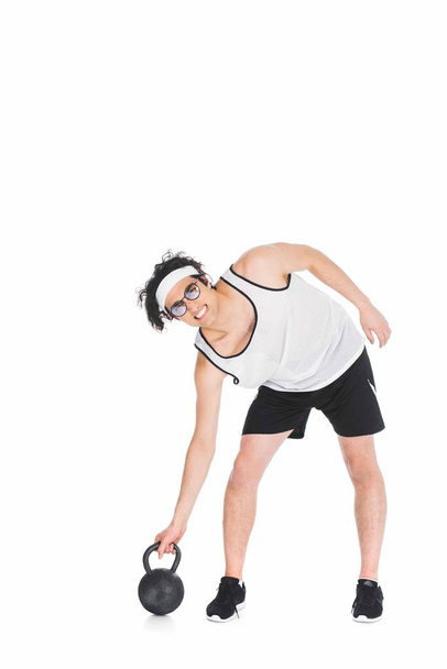 Thin sportsman in eyeglasses raising kettlebell isolated on white - Φωτογραφία, εικόνα